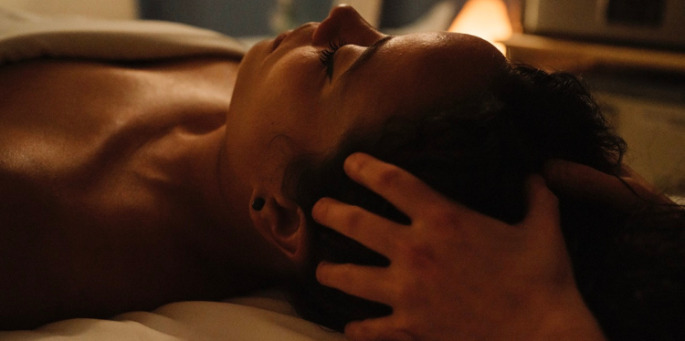 A woman receives craniosacral therapy from a massage therapist.